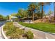 Scenic view of Willow Creek entrance with manicured lawns, decorative rock, and mature trees at 2846 Barrow Downs St, Las Vegas, NV 89135