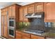 Close-up of kitchen with stainless steel appliances, granite countertops, and custom wood cabinetry at 2846 Barrow Downs St, Las Vegas, NV 89135