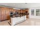 Spacious kitchen features custom wood cabinetry, large island, granite countertops and stainless steel appliances at 2846 Barrow Downs St, Las Vegas, NV 89135