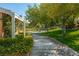 Lush walking path with bench seating, landscaped flowers, and shade trees at 2846 Barrow Downs St, Las Vegas, NV 89135