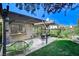 Relaxing backyard with a covered patio, lush lawn, and mature landscaping for outdoor enjoyment at 3013 Plaza De Rosa, Las Vegas, NV 89102