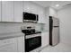 Renovated kitchen with stainless steel appliances and bright white cabinets at 3013 Plaza De Rosa, Las Vegas, NV 89102