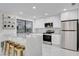 Well-lit kitchen with stainless appliances, bright white cabinets, and gold bar stools at 3013 Plaza De Rosa, Las Vegas, NV 89102