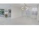 Open living space with sleek white floors, modern lighting, and seamless access to the kitchen and backyard at 3013 Plaza De Rosa, Las Vegas, NV 89102
