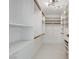 Bright walk-in closet with custom shelving, wooden rods, and stylish marble flooring at 3013 Plaza De Rosa, Las Vegas, NV 89102