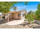 The backyard has a covered patio with a concrete floor and some small trees at 3053 Anchor Chain Dr, Las Vegas, NV 89128