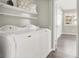 This laundry room contains a washing machine, a dryer, shelves and access to another room at 3053 Anchor Chain Dr, Las Vegas, NV 89128