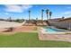 Backyard with pool, artificial turf, and desert landscaping featuring palm trees and privacy walls at 341 Waterwheel Falls Dr, Henderson, NV 89015