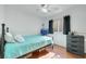 Comfortable bedroom with hardwood floors, ceiling fan, and a twin bed with blue bedding at 341 Waterwheel Falls Dr, Henderson, NV 89015