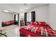 Cozy bedroom with a large mirror closet, tile floor, and a red floral comforter on the bed at 341 Waterwheel Falls Dr, Henderson, NV 89015
