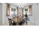 Dining room with a dark wood table with seating for six, chandelier, and window with curtains at 341 Waterwheel Falls Dr, Henderson, NV 89015