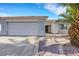 Single-story home with desert landscaping and palm trees adding curb appeal at 341 Waterwheel Falls Dr, Henderson, NV 89015
