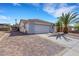 Charming single-story home with a spacious driveway, two-car garage, and desert landscaping with mature palm trees at 341 Waterwheel Falls Dr, Henderson, NV 89015
