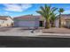 Attractive single-story home with a paved driveway, desert landscaping, and mature palm trees at 341 Waterwheel Falls Dr, Henderson, NV 89015