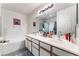 Bathroom featuring a double sink vanity, large mirror, and a tub with a tile surround at 3420 Winterhaven St # 202, Las Vegas, NV 89108