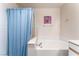 Bathroom featuring a soaking tub, blue shower curtain, and white tile surround at 3420 Winterhaven St # 202, Las Vegas, NV 89108