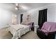 Bright bedroom showcasing a cozy bed with pink accents and soft carpet, illuminated by a ceiling fan and natural light at 3420 Winterhaven St # 202, Las Vegas, NV 89108