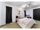 Bright bedroom showcasing a cozy bed with pink accents and soft carpet, illuminated by a ceiling fan and natural light at 3420 Winterhaven St # 202, Las Vegas, NV 89108
