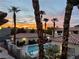 Charming community pool surrounded by lush landscaping and red tile roofs, under a beautiful sunset sky at 3420 Winterhaven St # 202, Las Vegas, NV 89108