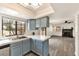 Bright kitchen featuring blue cabinets, stainless steel dishwasher, and a view into the open-concept living area at 3484 Nightflower Ln # 2, Las Vegas, NV 89121