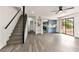 Spacious living room with staircase, updated flooring, and an open view into the kitchen with blue cabinets at 3484 Nightflower Ln # 2, Las Vegas, NV 89121