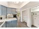 View of the kitchen with blue cabinets, next to a spacious, well-lit pantry with shelving for ample storage at 3484 Nightflower Ln # 2, Las Vegas, NV 89121