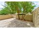 Enclosed patio area with a block wall, trees, and shade, perfect for outdoor relaxation or entertaining at 3484 Nightflower Ln # 2, Las Vegas, NV 89121