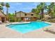 Inviting community pool area with clear blue water, lounge chairs, and shady palm trees at 3484 Nightflower Ln # 2, Las Vegas, NV 89121