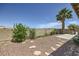 Landscaped backyard featuring gravel, stone steps, patio area, mature trees, and block wall fence for privacy at 3642 Winter Whitetail St, Las Vegas, NV 89122