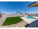 Inviting backyard with a refreshing pool, green artificial grass, desert landscaping, and privacy wall at 3986 Belleville Ave, Las Vegas, NV 89121