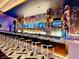 Long modern bar featuring colorful artwork and a variety of liquors on display at 4381 W Flamingo Rd # 2220, Las Vegas, NV 89103
