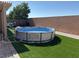 Backyard featuring a round above ground swimming pool, patio, and artificial grass at 4780 Lorenzo Way, Pahrump, NV 89061