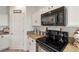 Kitchen showcasing a black microwave and oven, white cabinets and granite countertops at 4780 Lorenzo Way, Pahrump, NV 89061