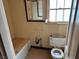 Dated bathroom with yellow tile, a tub, and an old toilet at 524 5Th St, Boulder City, NV 89005