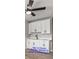 An efficient kitchen space with white cabinets and black hardware, underlit by a modern ceiling fan at 5453 Yvonne Cir, Las Vegas, NV 89122