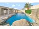 Backyard pool featuring rock features, palm trees, and a privacy fence at 5453 Yvonne Cir, Las Vegas, NV 89122