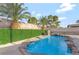 A beautiful backyard pool with rock features and lush greenery, great for relaxing at 5453 Yvonne Cir, Las Vegas, NV 89122