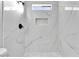 A renovated shower featuring marble-look tile, niche, rainfall shower head, and matte black hardware at 5453 Yvonne Cir, Las Vegas, NV 89122