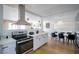 Modern kitchen with stainless steel appliances, white cabinetry, and an open floorplan dining area at 6301 Garwood Ave, Las Vegas, NV 89107