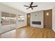 Well-lit living room with fireplace, hardwood floors, ceiling fan, and sliding glass doors to the backyard at 6388 Canyon Dawn Ave, Las Vegas, NV 89108