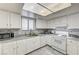Functional kitchen with white cabinets, marble countertops, and a stainless steel sink under the window at 6735 W Charleston Blvd # 4, Las Vegas, NV 89146