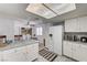 Open kitchen with white cabinets, marble countertops, stainless steel appliances, and a dining area at 6735 W Charleston Blvd # 4, Las Vegas, NV 89146
