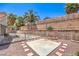 Backyard patio area with a concrete pad, red rock, and perimeter brick accents at 6961 Ray Charles Ln, Las Vegas, NV 89119