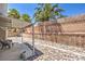 A backyard featuring river rock landscaping, a covered patio, and a tall block fence at 6961 Ray Charles Ln, Las Vegas, NV 89119