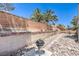 House backyard featuring river rock landscaping with a BBQ pit and brick wall at 6961 Ray Charles Ln, Las Vegas, NV 89119