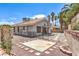 Home exterior featuring a backyard with a concrete pad, red rock, and brick perimeter at 6961 Ray Charles Ln, Las Vegas, NV 89119