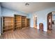 Bedroom featuring wood-look flooring, built-in bookshelves, and en-suite bathroom at 6961 Ray Charles Ln, Las Vegas, NV 89119