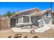Exterior of the house featuring a private side gate and desert landscaping at 6961 Ray Charles Ln, Las Vegas, NV 89119