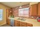 Cozy kitchen with wood cabinets, stainless steel sink, and brick accents at 6961 Ray Charles Ln, Las Vegas, NV 89119