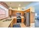 Functional kitchen with stainless steel appliances, wooden cabinetry, and a brick backsplash at 6961 Ray Charles Ln, Las Vegas, NV 89119